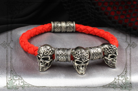 красный браслет с серебряными черепами и кельтскими шармами