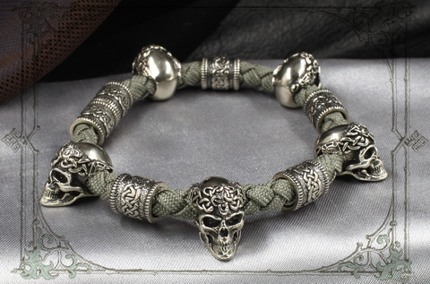 серый браслет с серебряными черепами и кельтскими шармами