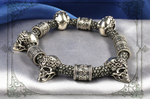 плетеный браслет с серебряными черепами и кельтскими шармами